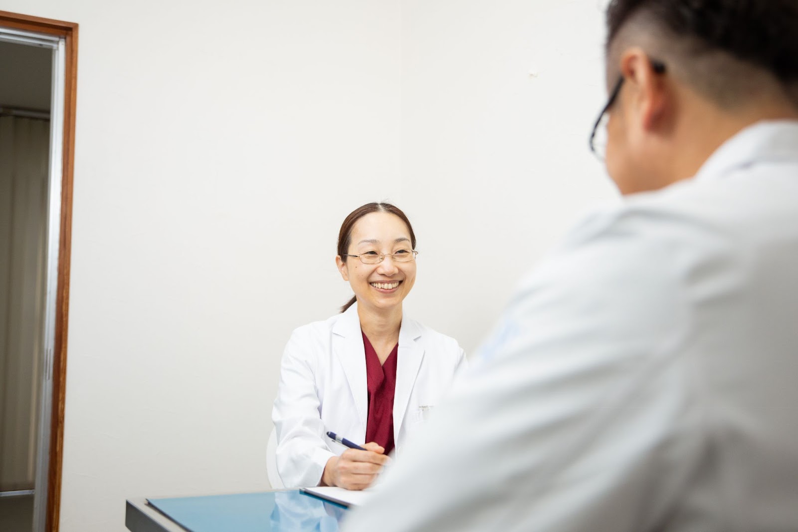 <img src="images/vet-consultation.jpg" alt="白衣の獣医師が飼い主様と向かい合い、診察内容を丁寧に聞き取りながらメモを取っている様子">